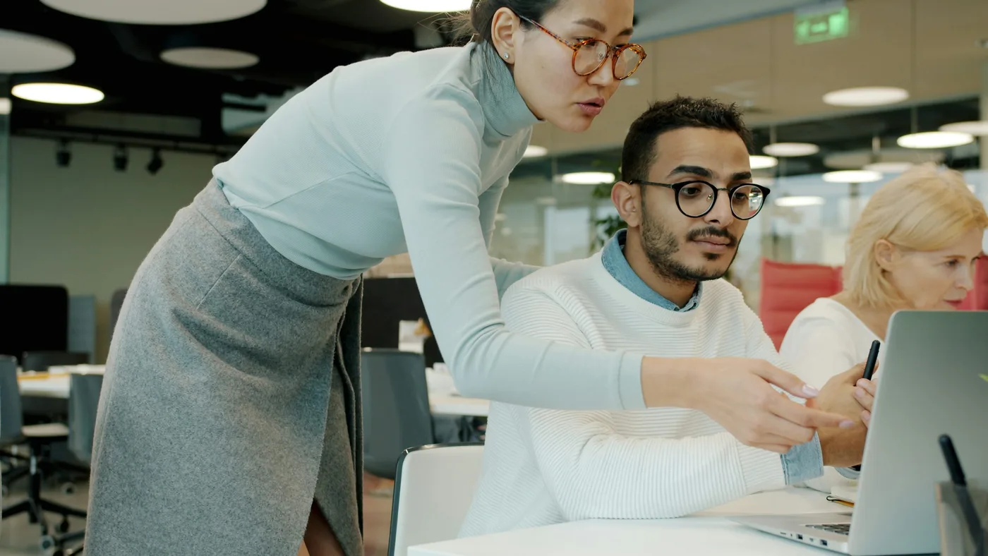 Colleagues reviewing a project together at a laptop.